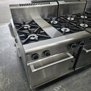 The WALDORF 4 Burner Space Saver Oven Range is a commercial stainless steel gas stove with four burners, black grates, front-panel knobs, and an oven below—perfect for those seeking reliable kitchen equipment. MRCE
