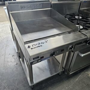 The GOLDSTEIN 600 ELECTRIC GRILL PLATE features stainless steel construction, side and back splashes, front control knobs, and a lower storage shelf—ideal for upgrading your Melbourne restaurant equipment. Marked #13024P Electric. MRCE