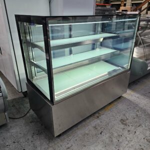 The BROMIC 1500MM DISPLAY FRIDGE, a spacious stainless steel and glass unit with three shelves, is perfect for showcasing commercial catering equipment in industrial settings with concrete floors. MRCE